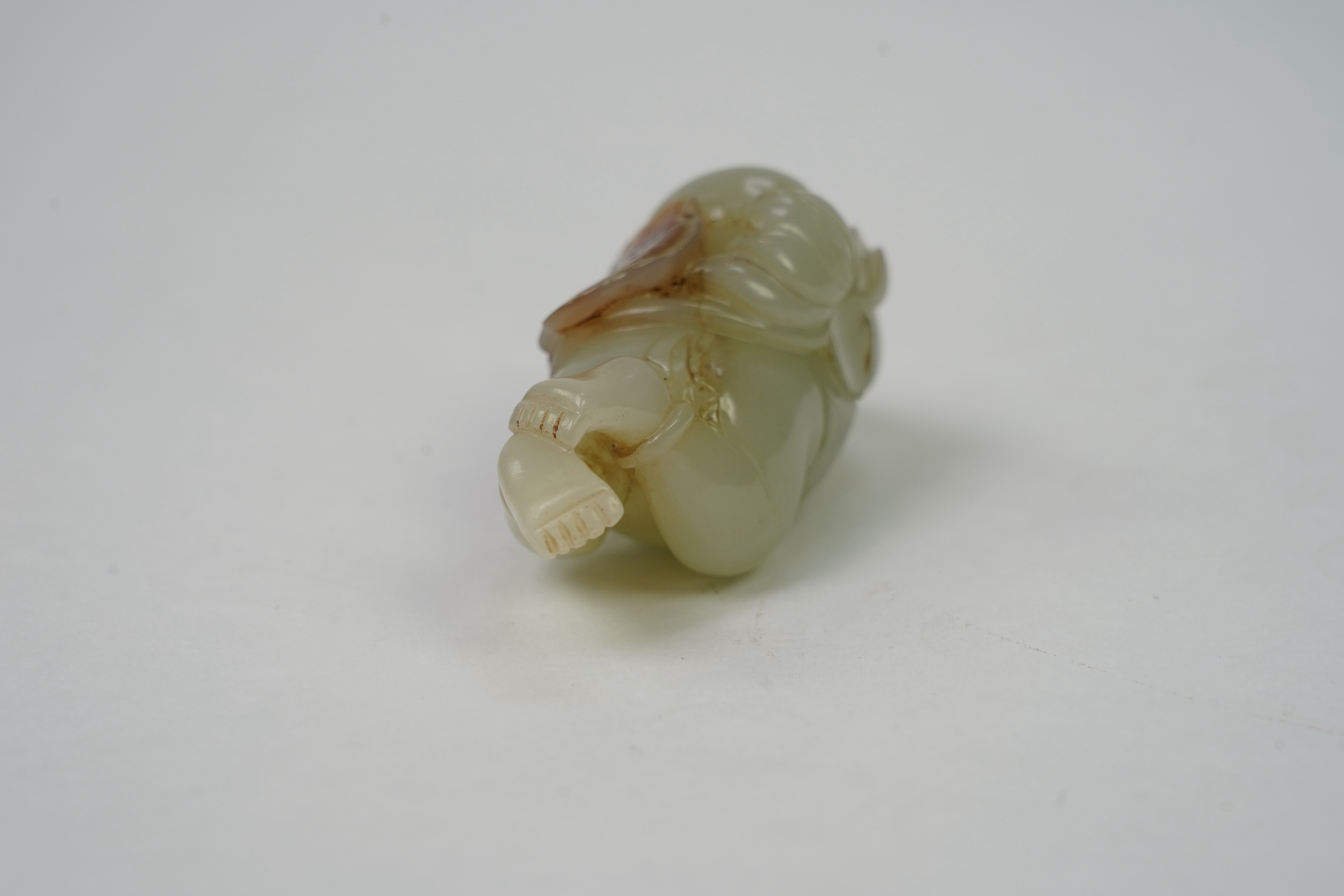 A Chinese pale celadon and russet skin jade figure of a boy and lotus